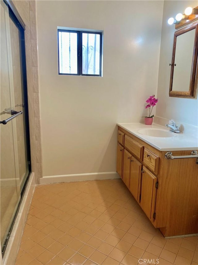 full bath with tile patterned floors, baseboards, vanity, and a stall shower