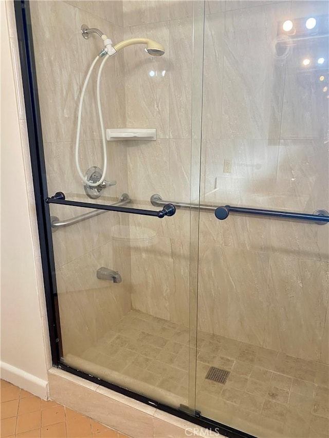 bathroom featuring a shower stall, tile patterned flooring, and baseboards