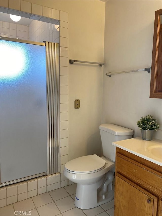 bathroom featuring an enclosed shower, vanity, tile patterned floors, and toilet