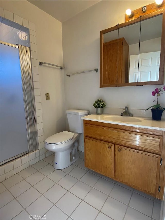 bathroom with a shower stall, tile patterned flooring, vanity, and toilet