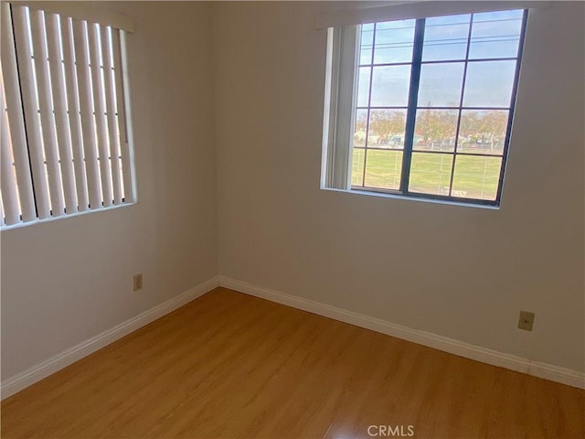 spare room with light wood finished floors and baseboards