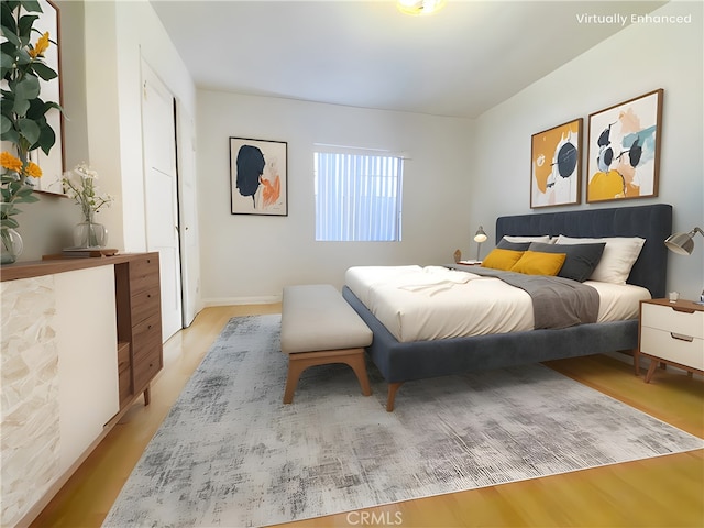 bedroom with light wood finished floors and baseboards