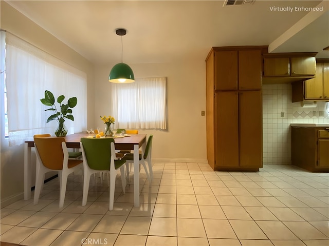 dining space featuring baseboards, visible vents, and light tile patterned floors