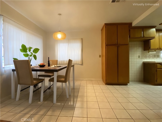 dining area with light tile patterned flooring, visible vents, and baseboards