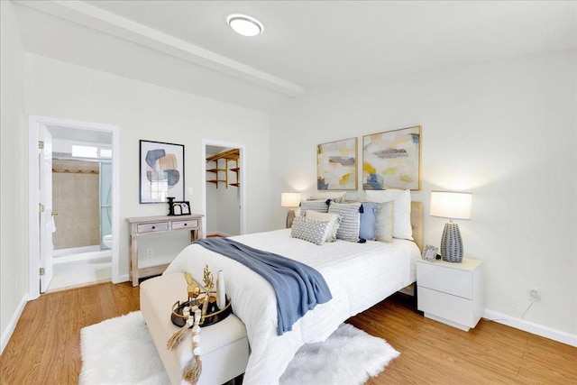 bedroom featuring lofted ceiling with beams and light hardwood / wood-style floors