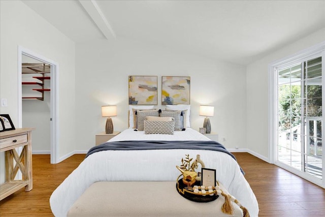 bedroom with wood-type flooring, multiple windows, and access to outside