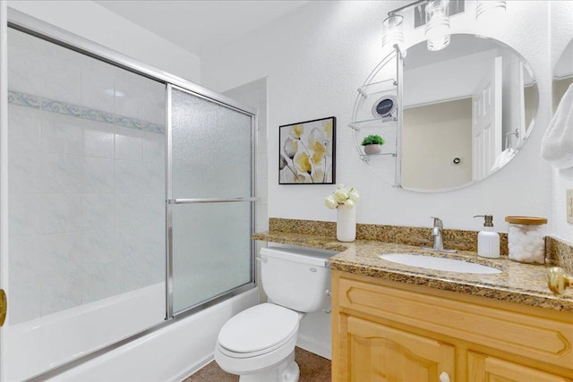 full bathroom featuring vanity, shower / bath combination with glass door, and toilet