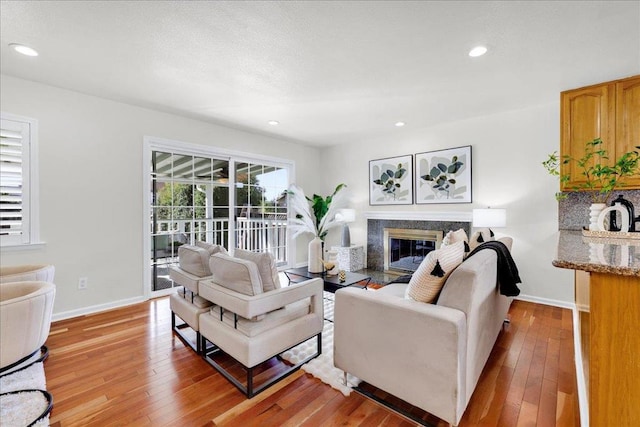 living room with light wood-type flooring, a fireplace, and plenty of natural light