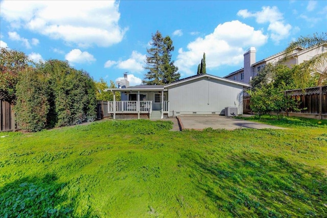 rear view of house featuring central AC, a patio, and a lawn