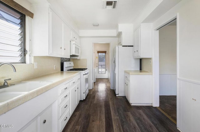 kitchen featuring white appliances, dark hardwood / wood-style flooring, sink, and white cabinets