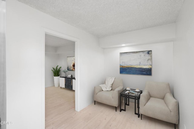 living area featuring a textured ceiling and light wood-type flooring