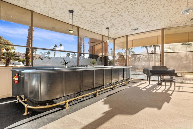 interior space featuring floor to ceiling windows, carpet flooring, and a mountain view