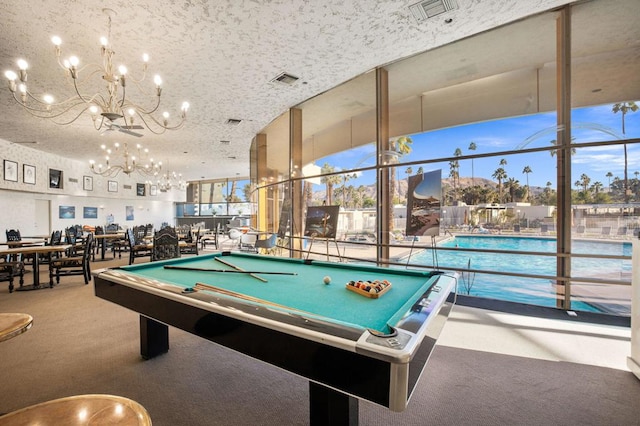 rec room with floor to ceiling windows, a textured ceiling, and carpet