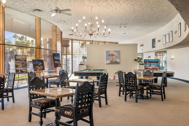 carpeted dining space with expansive windows and ceiling fan