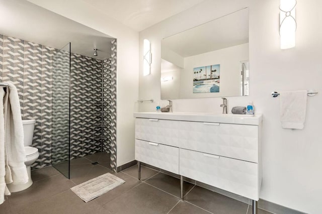 bathroom with vanity, tile patterned floors, toilet, and walk in shower