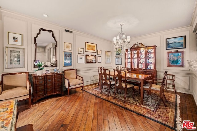 dining room featuring ornamental molding, a notable chandelier, and light wood-type flooring