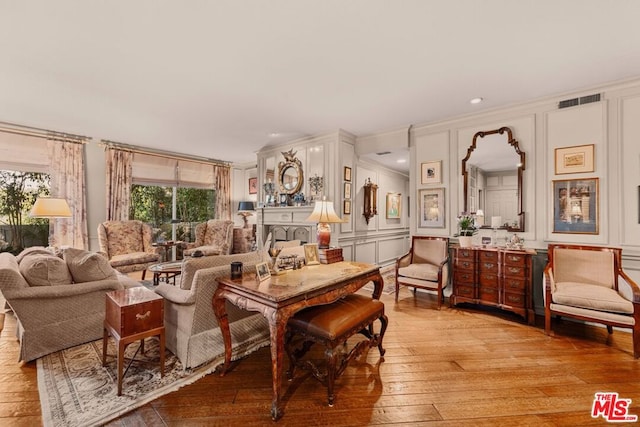 sitting room featuring crown molding and light hardwood / wood-style floors