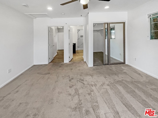 unfurnished bedroom with light colored carpet, a closet, and ceiling fan