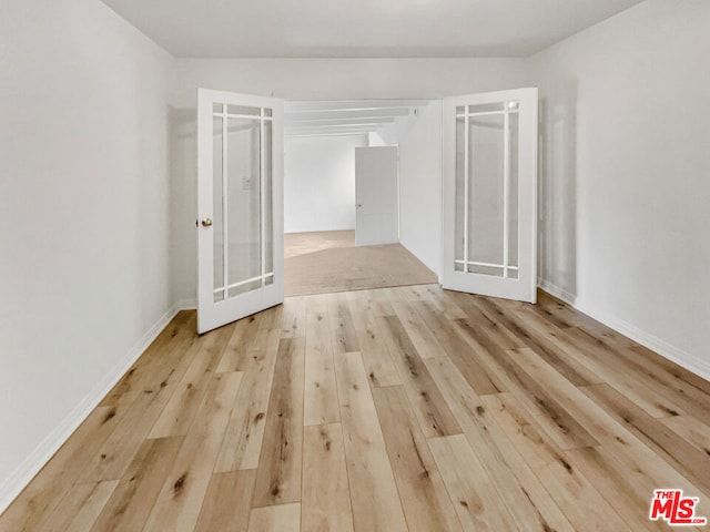 empty room featuring light hardwood / wood-style floors and french doors