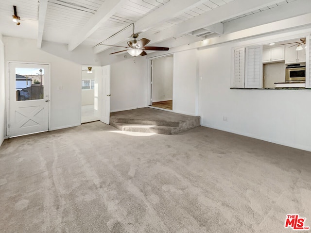 unfurnished living room featuring ceiling fan, beam ceiling, light colored carpet, and wooden ceiling