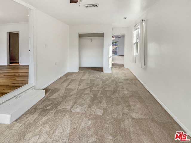 carpeted spare room featuring ceiling fan