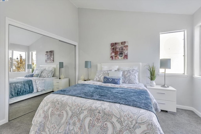 bedroom with light carpet, lofted ceiling, and a closet