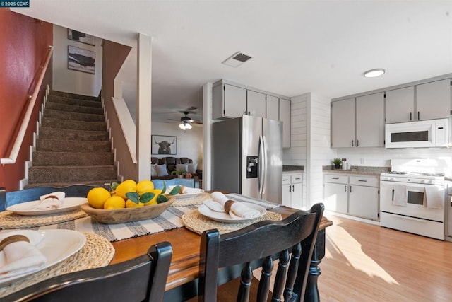 kitchen featuring tasteful backsplash, white appliances, light wood-type flooring, gray cabinets, and ceiling fan