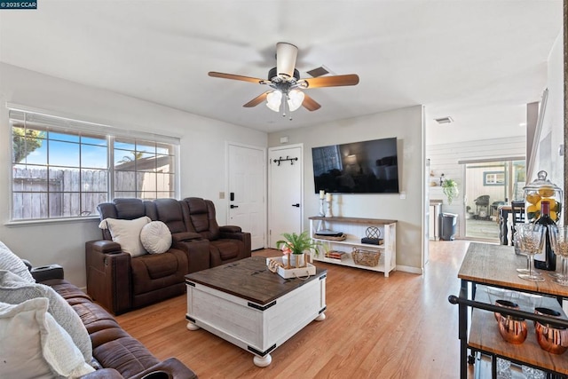 living room featuring ceiling fan, plenty of natural light, and light hardwood / wood-style floors