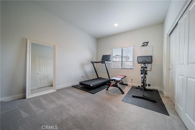 exercise area with vaulted ceiling and light carpet