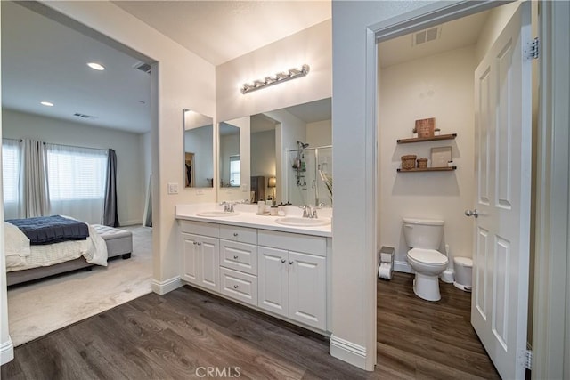 bathroom featuring vanity, hardwood / wood-style floors, an enclosed shower, and toilet