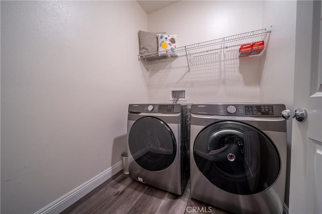 laundry area featuring washer and dryer and dark wood-type flooring