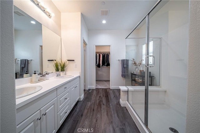 bathroom featuring vanity, wood-type flooring, and walk in shower