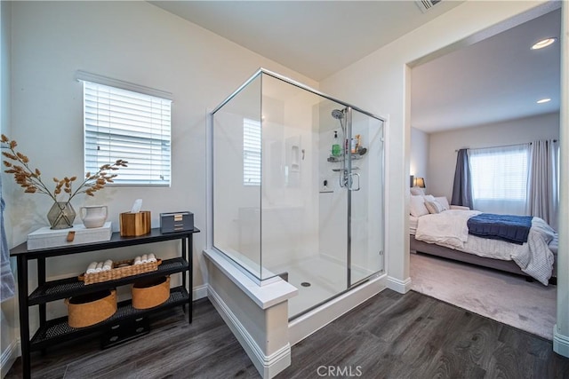 bathroom with a shower with door and hardwood / wood-style floors