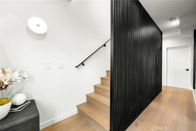 stairway featuring baseboards and wood finished floors