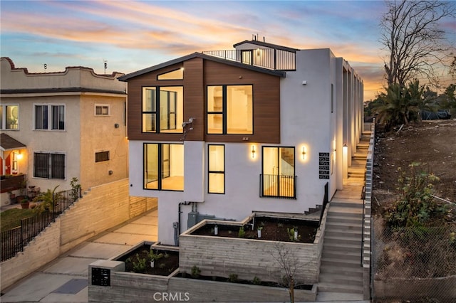 view of front of property with stairway and stucco siding