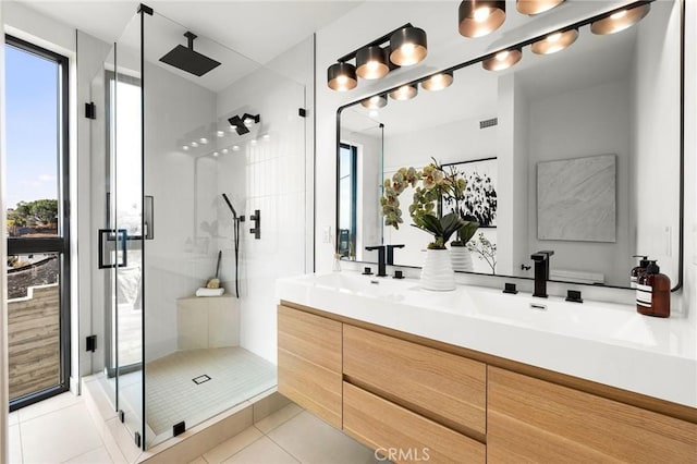 full bathroom featuring double vanity, a stall shower, plenty of natural light, and tile patterned flooring