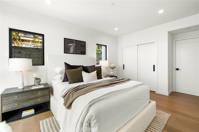 bedroom with a closet, wood finished floors, and recessed lighting