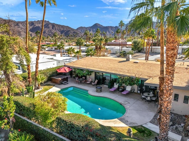 view of pool with a jacuzzi, a patio area, and a mountain view