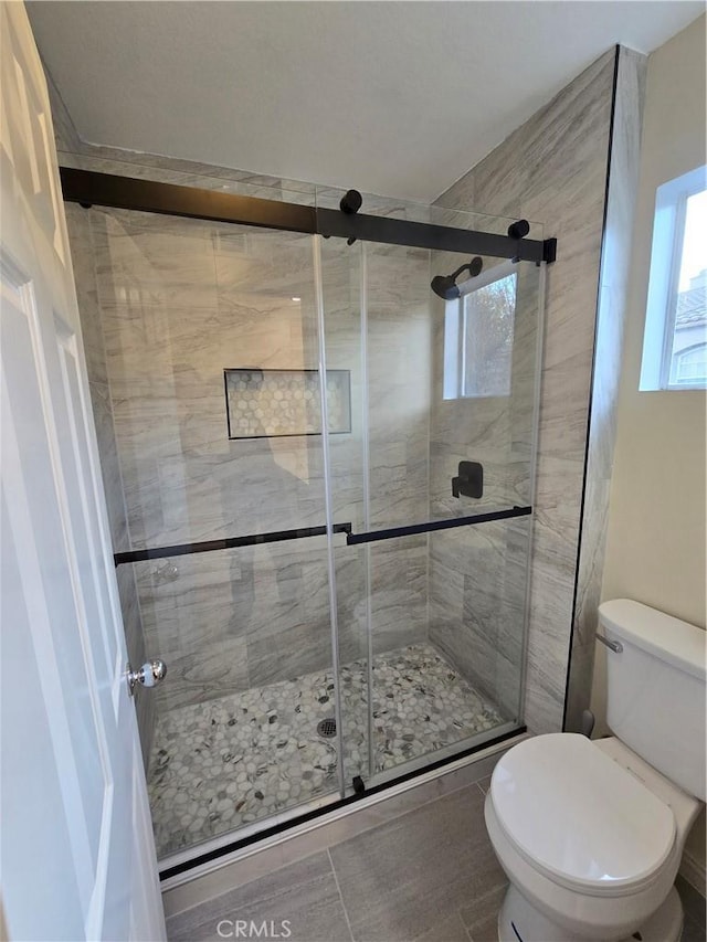 bathroom featuring an enclosed shower and toilet