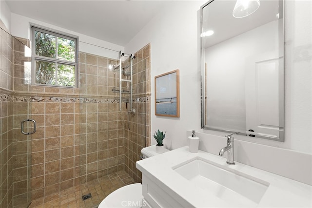 bathroom featuring vanity, a shower with shower door, and toilet