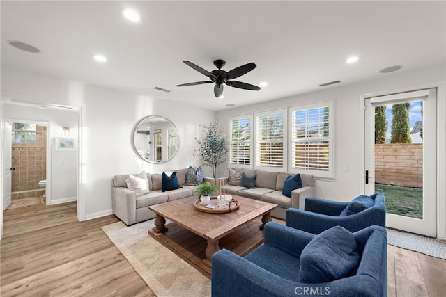 living room with ceiling fan, plenty of natural light, and light hardwood / wood-style flooring