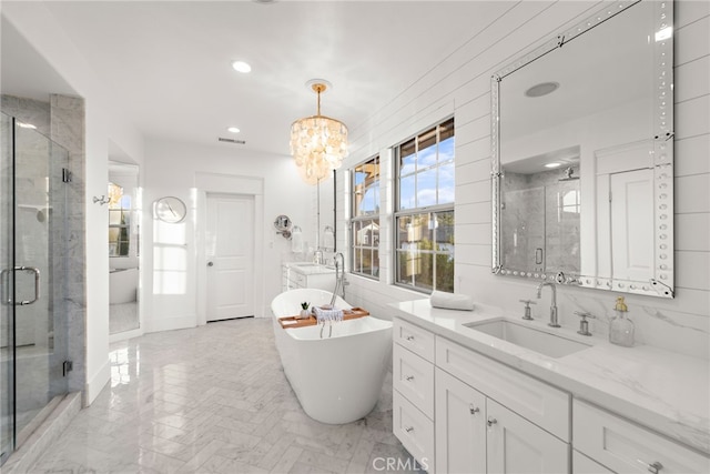 bathroom featuring vanity, independent shower and bath, and a notable chandelier