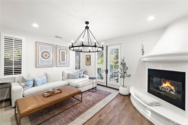 living room featuring an inviting chandelier, a fireplace, and hardwood / wood-style floors