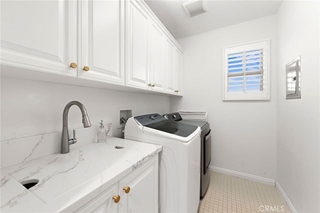 laundry area with cabinets, separate washer and dryer, and sink