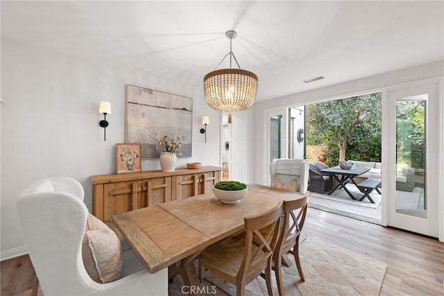 dining space with an inviting chandelier and light wood-type flooring