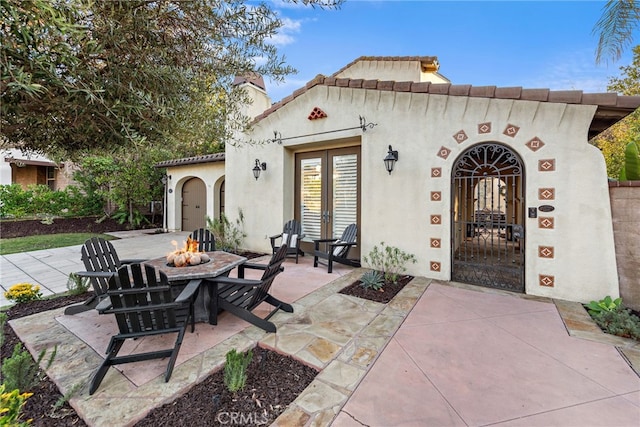 view of patio / terrace featuring french doors and an outdoor fire pit