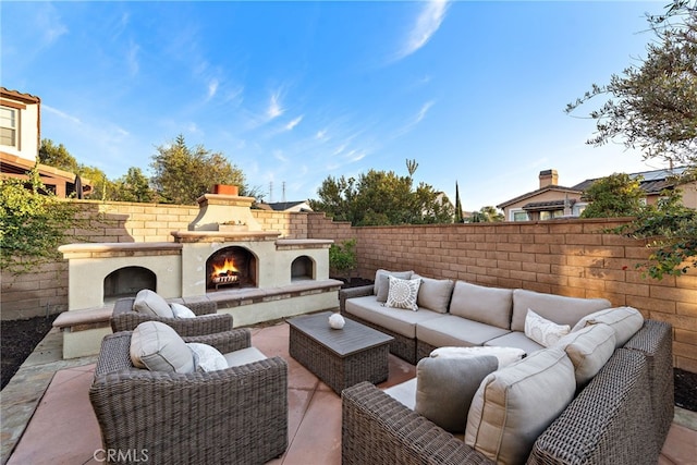 view of patio / terrace with an outdoor living space with a fireplace