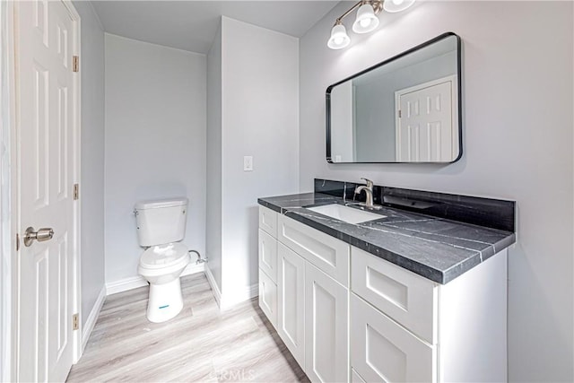 bathroom featuring vanity, hardwood / wood-style floors, and toilet