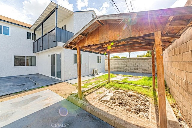 exterior space featuring central AC unit, a patio, and a balcony