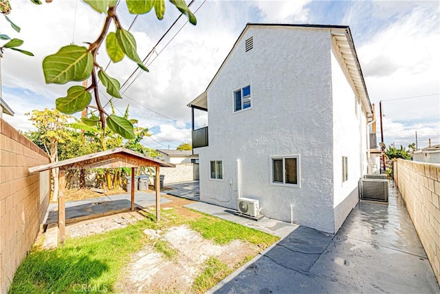 rear view of property featuring a patio area and ac unit